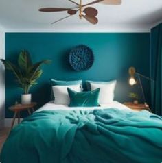 a bedroom with teal walls and white bedding, green curtains, and a ceiling fan