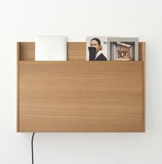 a wooden shelf with magazines and pictures on it