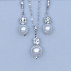 "This pretty Swarovski pearl and pavè crystal bridal jewelry set is an elegant and modern twist on a classic. We've designed the set with 10 mm ivory white pearls and cz french hooks with a matching necklace using a slightly larger pearl pendant. It make a great ready-to-go set! Measurements: Earrings -1 1/2\" Pendant -1.2\" and is on a 16\"-18\" rhodium plated sterling silver chain.(including extender) ★Shopping for your bridal party? Contact us for special pricing. ♥♥Models own ear posts worn Silver Pearl Bridal Sets For Formal Occasions, Formal Silver Pearl Bridal Sets, Elegant Pearl Bridal Sets With Pearl Drop, Elegant Pearl Bridal Sets For Formal Occasion, Elegant White Bridal Sets With Pearl Drop, Elegant Pearl Bridal Sets For Weddings, Elegant Pearl Drop Bridal Set For Wedding, White Pearl Drop Bridal Sets For Wedding, Classic White Jewelry Sets For Wedding