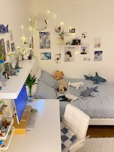 a bed room with a neatly made bed and a laptop on the desk next to it