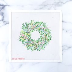 a cross - stitch card with a wreath on it