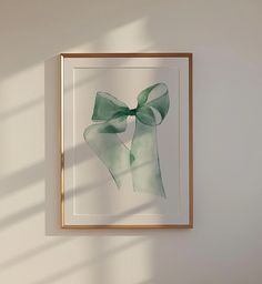 a framed photograph with a green bow hanging on the wall next to a white wall