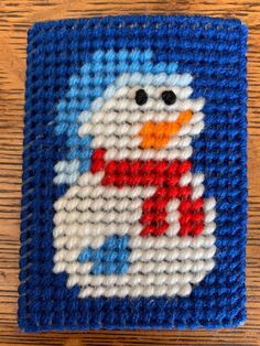 a blue and white needled coaster with a snowman design on it's side