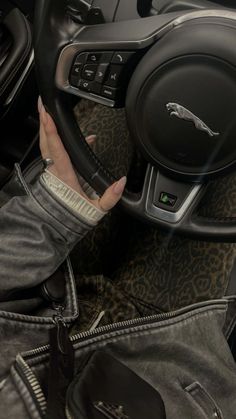 the interior of a car with a woman's hand on the steering wheel and leopard print carpet