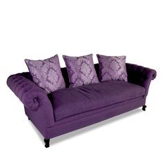 a purple couch with four pillows on it