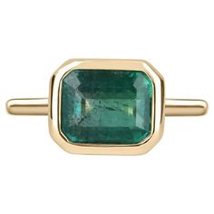 For Sale on 1stDibs - Displayed is a vibrant-green emerald, solitaire, emerald-cut bezel ring in 14K yellow gold. This gorgeous solitaire ring carries a full 3.85-carat emerald Stone Gold Ring, Bezel Set Engagement Ring, Bezel Engagement Ring, Jupiter Fl, Bezel Set Ring, Emerald Cut Rings, Solitaire Setting, Emerald Engagement Ring Cut, Bezel Ring