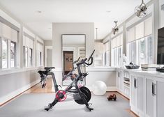 an exercise bike is in the middle of a room with white walls and flooring