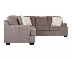 a gray sectional couch with pillows on the back and armrests, in front of a white background