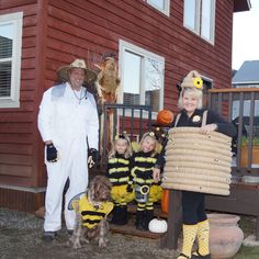 a man and two children dressed up as bee costumes with a woman holding a basket