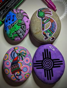 four painted rocks sitting on top of a table