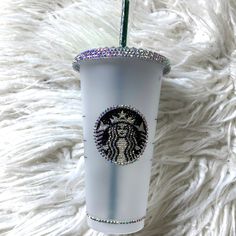 the starbucks cup is decorated with swaroons and sparkles on it's side