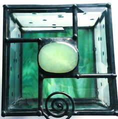 a green and white glass box with a spiral design in the center, on a white background