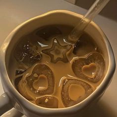 a cup filled with liquid sitting on top of a white counter next to a spoon