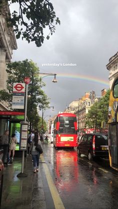 a red double decker bus driving down a rain soaked street