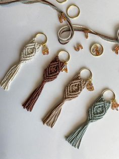 several different types of key chains on a white table with rings and beads hanging from them