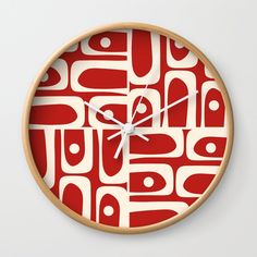 a red and white wall clock with an abstract design on the front, side and back