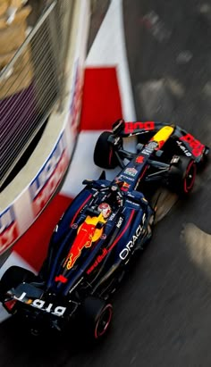 a red bull racing car driving down the street