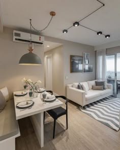 a living room and dining area with white furniture