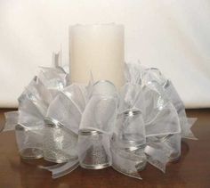 a candle is sitting on a table with some organe ribbons and bows around it