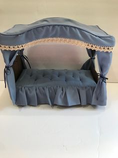 a blue bed with ruffles and lace on the top is shown in front of a white background