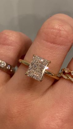 a woman's hand with two different rings and one diamond ring on the other