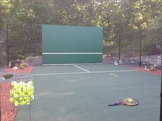 there is a tennis court with balls and racket on the ground next to it