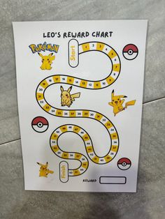 a pokemon board game is shown on the floor next to a sign that says leo's reward chart