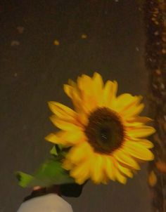 a yellow sunflower in a white vase