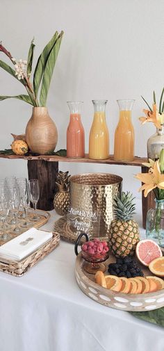 a table topped with lots of different types of fruit and glasses on top of it