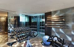 there are many exercise bikes in the room with mirrors on the wall and lights on the floor