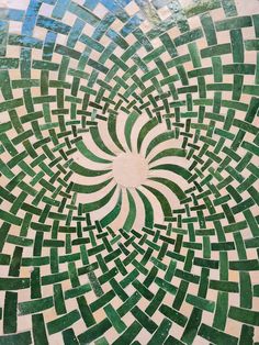 a green and white mosaic design on the side of a building