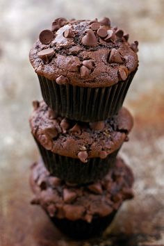 three chocolate muffins stacked on top of each other