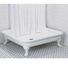 a white bath tub sitting next to a tiled wall