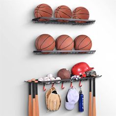 there are several sports items hanging on the wall and two racks holding balls, mitts, gloves and baseball bats