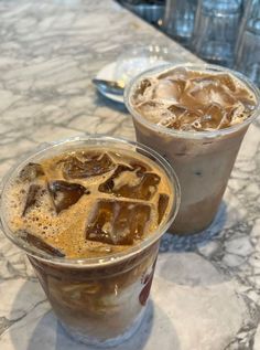 two iced drinks sitting on top of a table