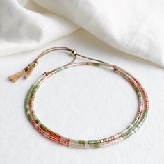 This delicate double wrap silk bracelet with a golden orange, succulent green and apricot beige glass beads has a sliding clasp to adjust to your size. As part of the California Dreaming collection the Joshua Tree bracelet is inspired by the Joshua Tree National park which is said to have a strong spiritual energy. On a natural beige silk cord with high quality tiny Japanese glass beads and 14k gold filled sliding clasp and beads. Fits an average wrist size of up to 7 inches and tightens to 6.25in. Extends to maximum of 8.5in to fit over the widest part of the hand. If you have a smaller or larger wrist and hands and would like a custom size please contact me. Displayed in one of our pretty gift boxes, so fantastic as a present for a friend or to yourself! Shipping Uk: 2-3 days - Royal Mai Boho Bracelets Stack, The Joshua Tree, Silk Bracelet, Beige Silk, Double Wrap Bracelet, Hippie Bracelets, Spiritual Energy, Gold Bead Bracelets, Joshua Tree National Park