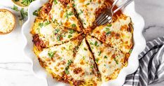 a casserole dish with meat and cheese on the side, topped with parsley