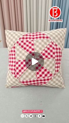 a red and white pillow sitting on top of a table