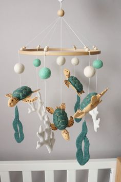 a crib mobile with sea turtles and turtle shells hanging from it