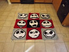 the kitchen floor is decorated with knitted rugs that have skulls and faces on them