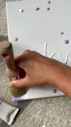 a person is using a brush to decorate a wall with polka dot dots on it