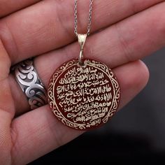 This 14k gold plated silver ayatul kursi necklace is a beautiful and meaningful piece of jewelry that combines the power of the holy verse with the energy of the red agate stone. The Ayatul Kursi is the 255th verse of the 2nd surah of the Quran and is considered one of the most powerful verses in Islam. The verse is hand-written in elegant calligraphy on a red agate stone, set in a silver pendant. The red agate is believed to promote strength and courage, making this necklace not only beautiful but also imbued with powerful energy. The necklace hangs from a matching silver chain and is perfect for daily wear. It's a great way to keep the blessings and protection of the Ayatul Kursi close to your heart. Are you looking for a truly unique and special piece of jewelry? Look no further than ha Traditional Etched Necklace For Gift, Carved Yellow Gold Necklace Perfect For Gift, Carved Yellow Gold Necklace For Gift, Traditional Carnelian Necklace For Gift, Carved Yellow Gold Necklace, Red Engraved Spiritual Necklaces, Gold Amulet Style Agate Necklaces, Islam Goals, Red Spiritual Engraved Necklace