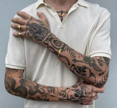 a man with tattoos on his arm and wrist holding onto another person's arm