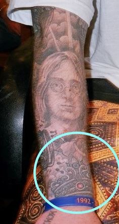 a man with tattoos on his arm has a blue circle around the wrist that reads,