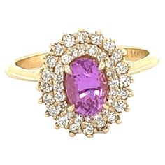 This beautiful ring has a Natural Oval Cut Heated Pink Sapphire that weighs 0.94 Carats. The Pink Sapphire is 7 mm x 5 mm. The ring is embellished with 40 Round Cut Diamonds that weigh 0.40 Carats with a clarity and color of VS/F. The total carat weight of the ring is 1.34 Carats. The ring is beautifully set in 14 Karat Yellow Gold with an approximate weight of 4.0 grams. It is a size 6 3/4 and can be re-sized if needed, free of charge. Dazzling Pink Sapphire Rings With Brilliant Cut, Classic Oval Amethyst Ring With Diamond, Fine Jewelry Pink Sapphire Diamond Ring With Halo Setting, Elegant Pink Sapphire Ring With Halo Setting, Dazzling Oval Pink Sapphire Jewelry, Classic Yellow Gold Sapphire Ring With Halo, Oval Brilliant Cut Amethyst Ring In Fine Jewelry Style, Oval Brilliant Cut Amethyst Ring Fine Jewelry, Oval Diamond Amethyst Ring In Fine Jewelry Style