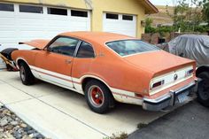 an orange car parked in front of a garage