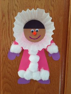 a paper plate doll hanging on a door