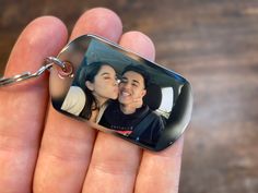 a person holding a keychain with a photo on it