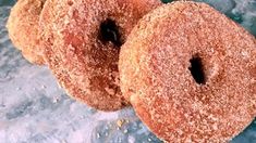 three sugar covered donuts sitting on top of a table