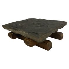 a stone table with two wooden legs